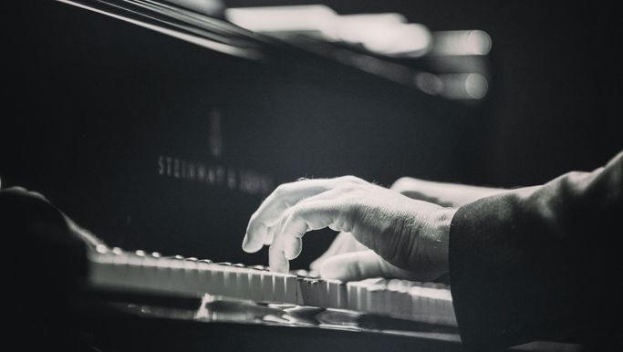 Svartvit bild på ett par händer som spelar piano